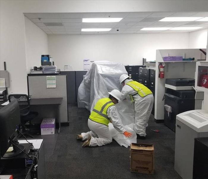 workers covering office furniture