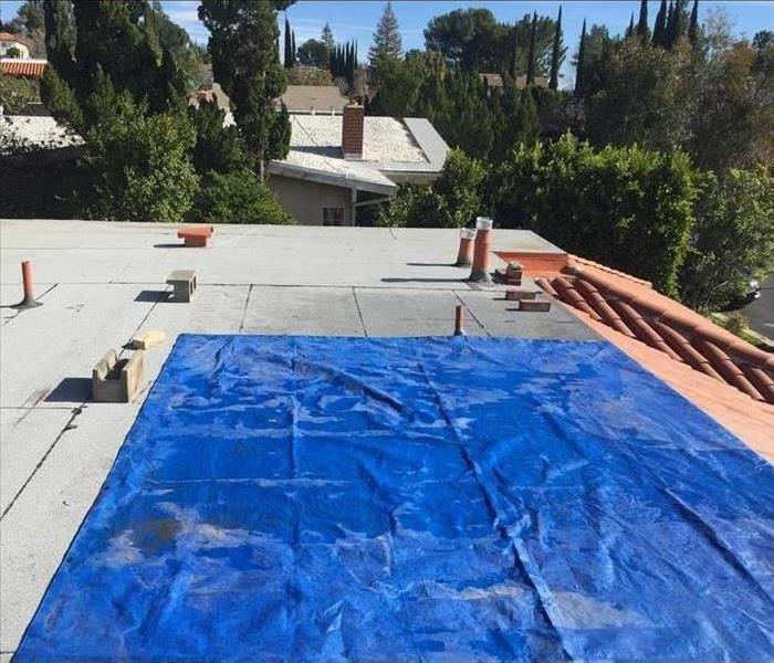 damaged wet roof with a tarp